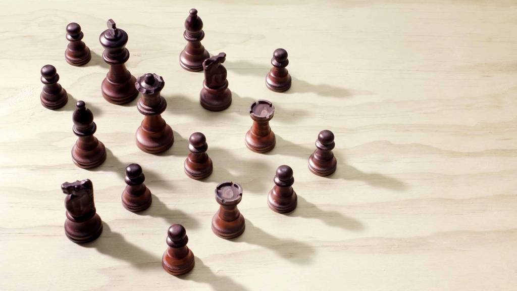 Fichas marrones de ajedrez sobre suelo de madera color crema