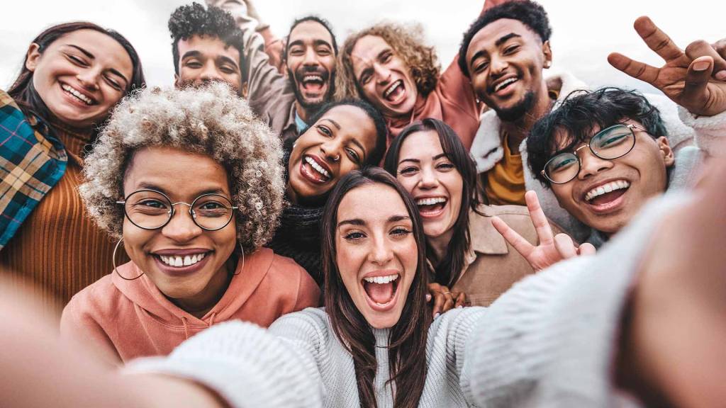Selfie de un grupo de amigos con rasgos fenotípicos de diversos grupos culturales sonriendo