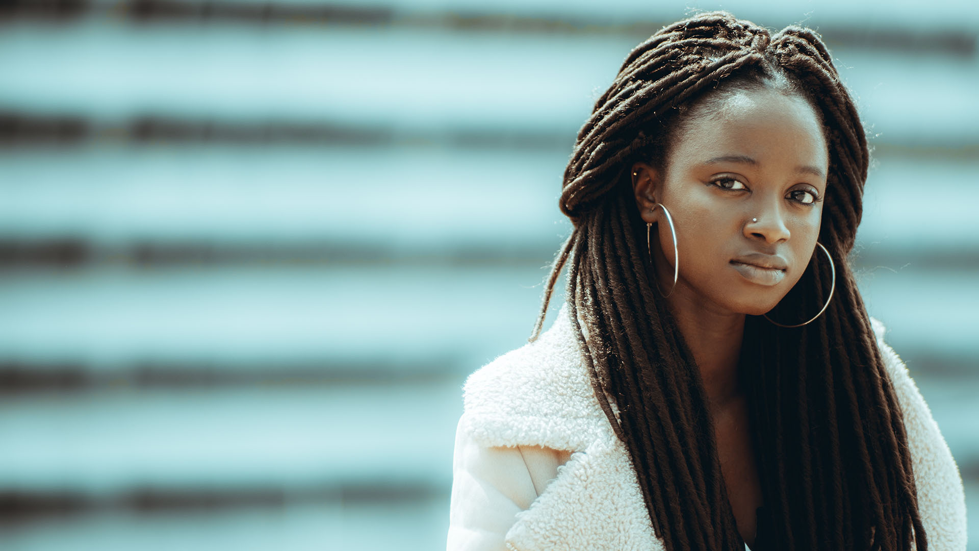 Mujer de rasgos fenotípicos africanos de pelo largo y argollas